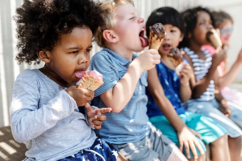 Group of kids eating ice cream on a bench