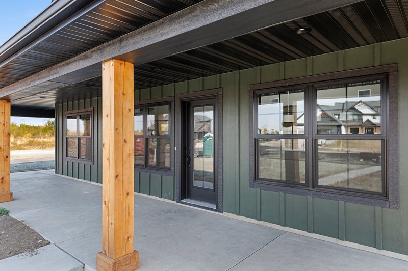 Green sided home with wood pillars in front