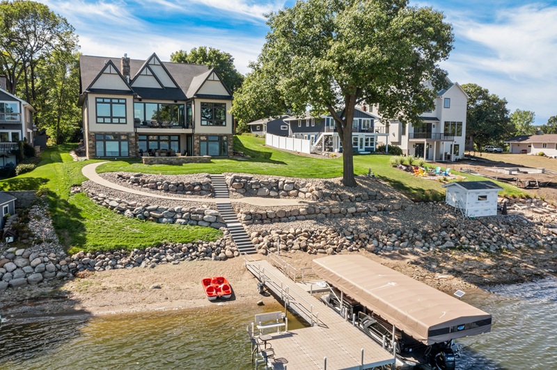 Custom backyard landscaped with rock and dock access to lake