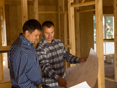 Builders reviewing blueprints for custom home